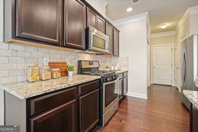 kitchen with crown molding, dark brown cabinets, stainless steel appliances, dark hardwood / wood-style floors, and decorative backsplash