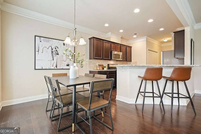 dining area featuring ornamental molding, dark hardwood / wood-style floors, and an inviting chandelier