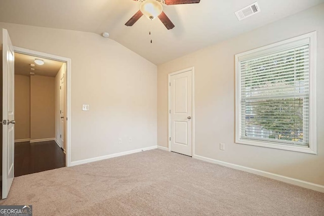 unfurnished bedroom with ceiling fan, lofted ceiling, and carpet