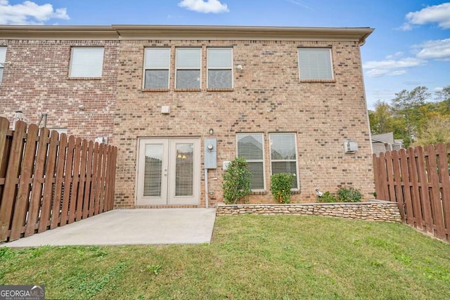 rear view of house with french doors, a yard, and a patio