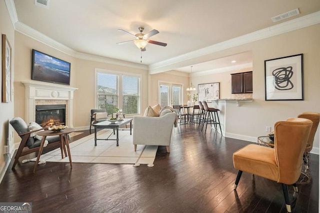 living room with hardwood / wood-style flooring, ornamental molding, and ceiling fan