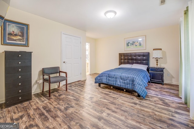 bedroom with visible vents, wood finished floors, and baseboards