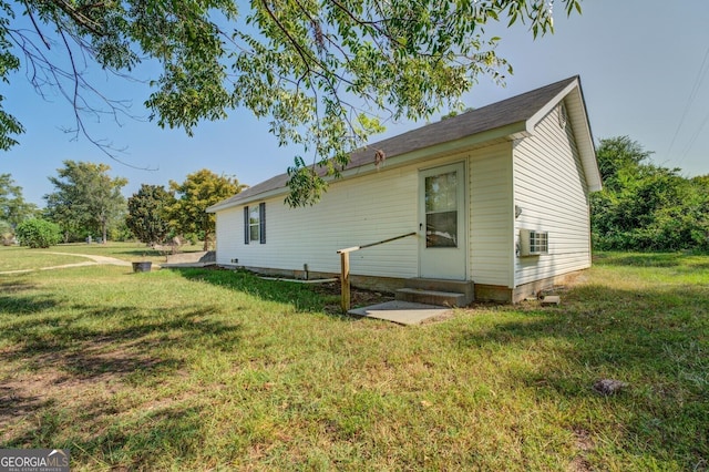 back of house with entry steps and a yard