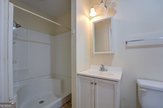 bathroom featuring a shower, toilet, and vanity