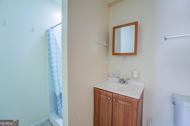 bathroom with vanity, a shower with shower curtain, and toilet