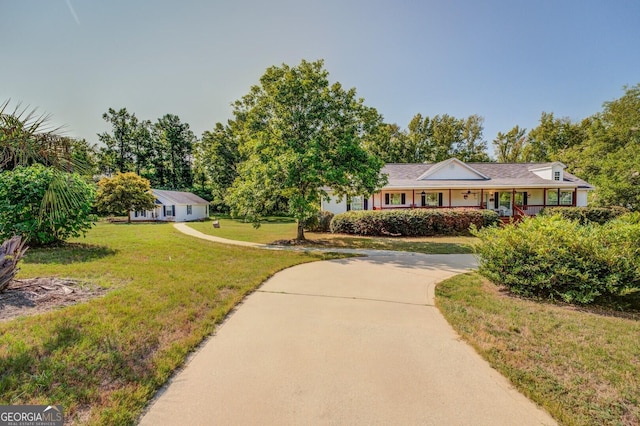 ranch-style house with a porch, concrete driveway, and a front yard