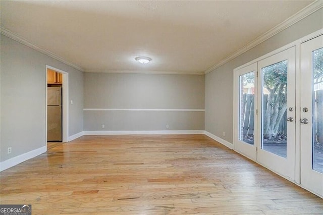 unfurnished room featuring light hardwood / wood-style flooring, ornamental molding, and french doors