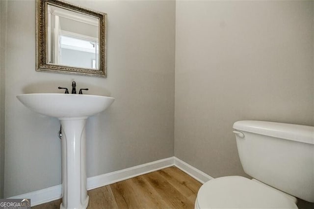 bathroom with hardwood / wood-style floors and toilet