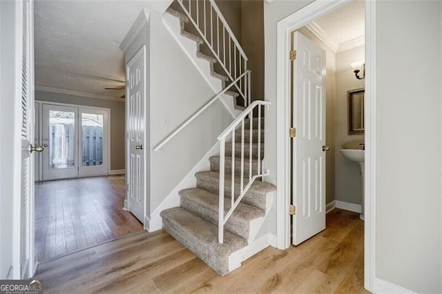 stairway with hardwood / wood-style flooring and ornamental molding