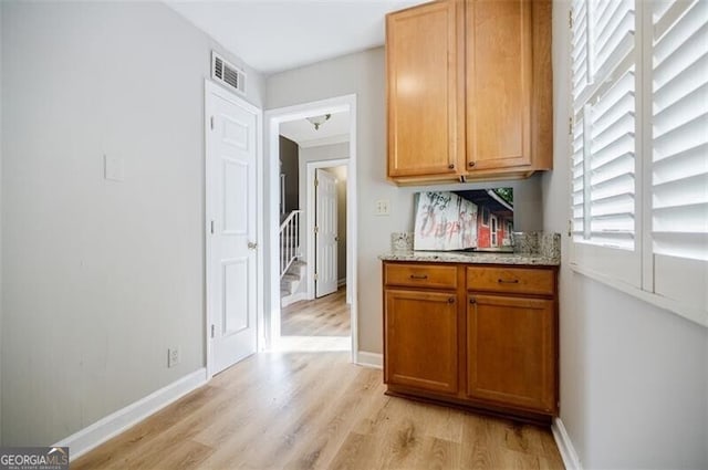 kitchen with light stone countertops and light wood-type flooring