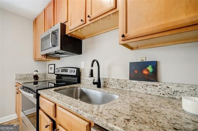 kitchen with sink, hardwood / wood-style floors, stainless steel appliances, light stone countertops, and light brown cabinets