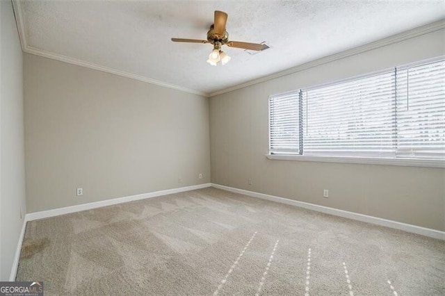 spare room featuring crown molding, light colored carpet, ceiling fan, and a textured ceiling