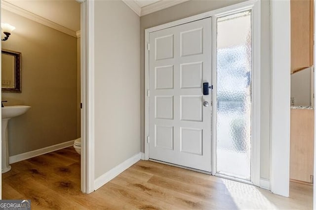 foyer featuring crown molding, a wealth of natural light, and light wood-type flooring