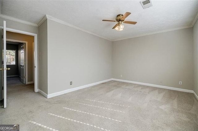 empty room featuring crown molding, light colored carpet, and ceiling fan