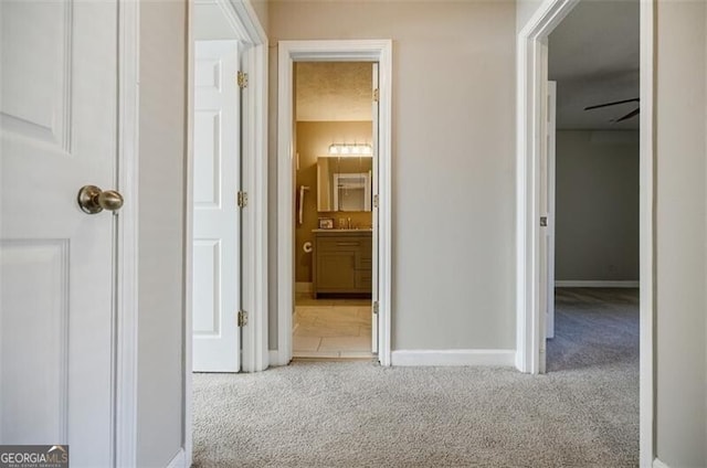 hallway featuring light colored carpet