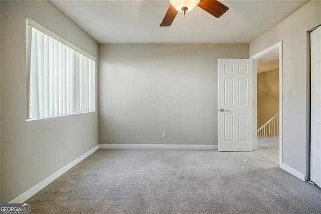 empty room featuring light colored carpet and ceiling fan