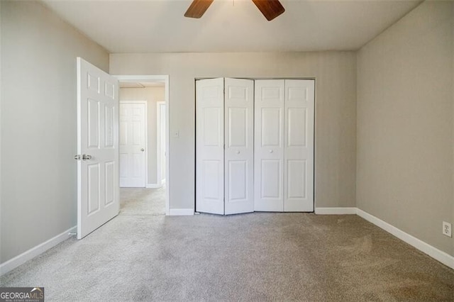 unfurnished bedroom featuring ceiling fan, a closet, and light carpet