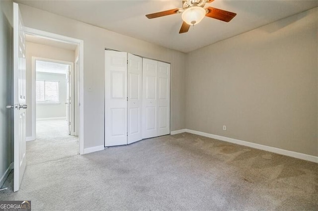 unfurnished bedroom with ceiling fan, a closet, and light carpet