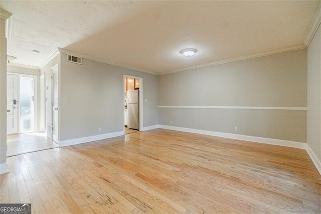 unfurnished room with crown molding and light wood-type flooring