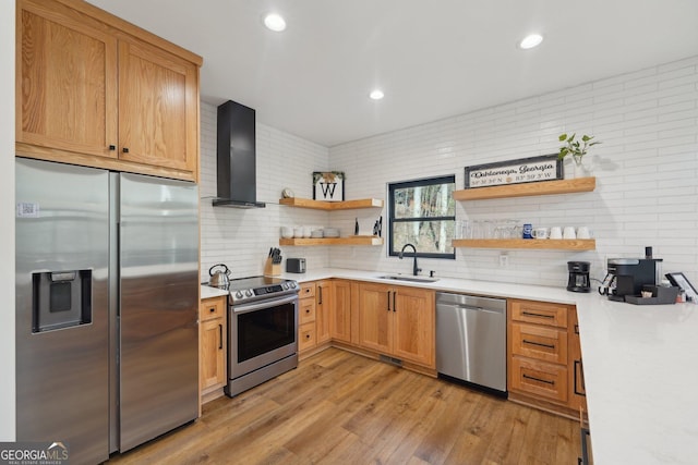 kitchen with wall chimney range hood, sink, stainless steel appliances, light hardwood / wood-style floors, and decorative backsplash