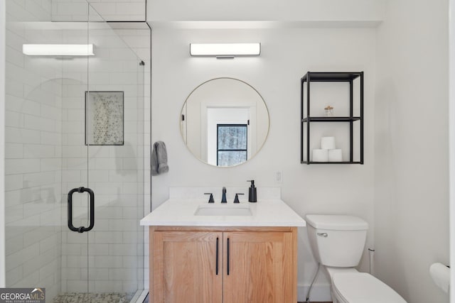 bathroom featuring vanity, toilet, and a shower with door