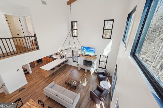 living room featuring hardwood / wood-style floors, a towering ceiling, and a chandelier