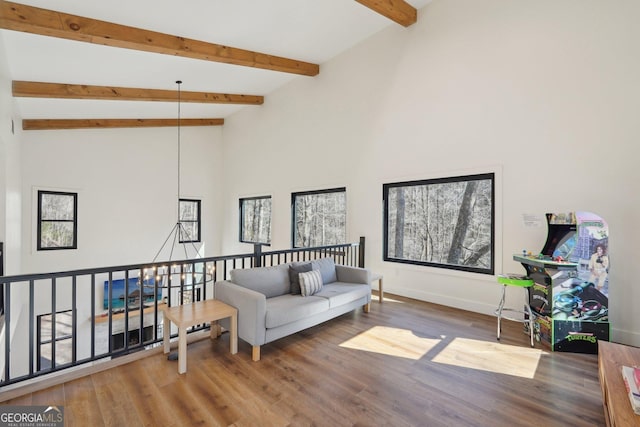 living room with a wealth of natural light, wood-type flooring, and beamed ceiling