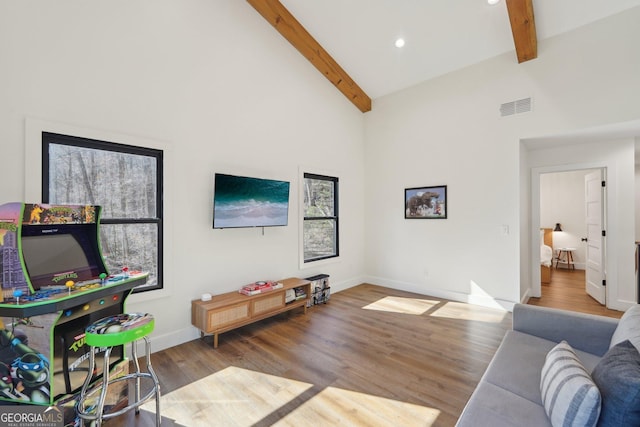 living room with hardwood / wood-style flooring, high vaulted ceiling, and beam ceiling