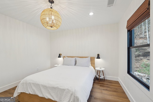 bedroom featuring dark hardwood / wood-style floors and a chandelier