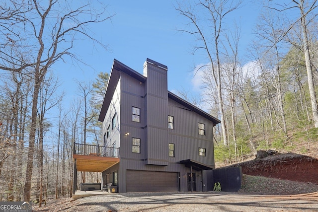 581 Etowah Trl, Dahlonega, GA 30533 - view of property exterior with an attached garage, dirt driveway, a chimney, and a deck