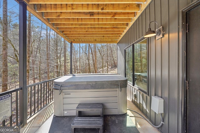 view of patio featuring a hot tub and a balcony