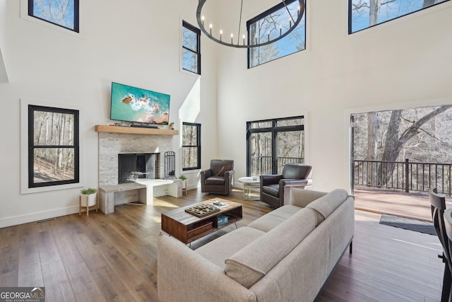 living room with hardwood / wood-style flooring, a notable chandelier, and a fireplace