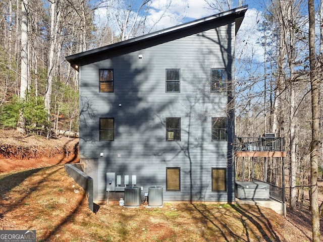 view of side of home featuring a yard and central AC