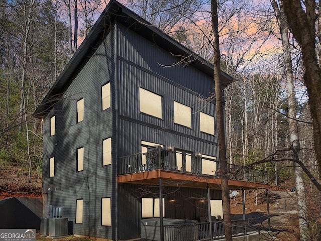 back house at dusk featuring cooling unit