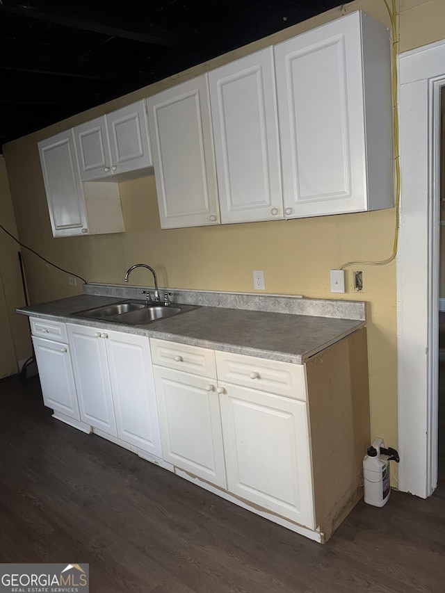 kitchen with white cabinetry, sink, and dark wood-type flooring