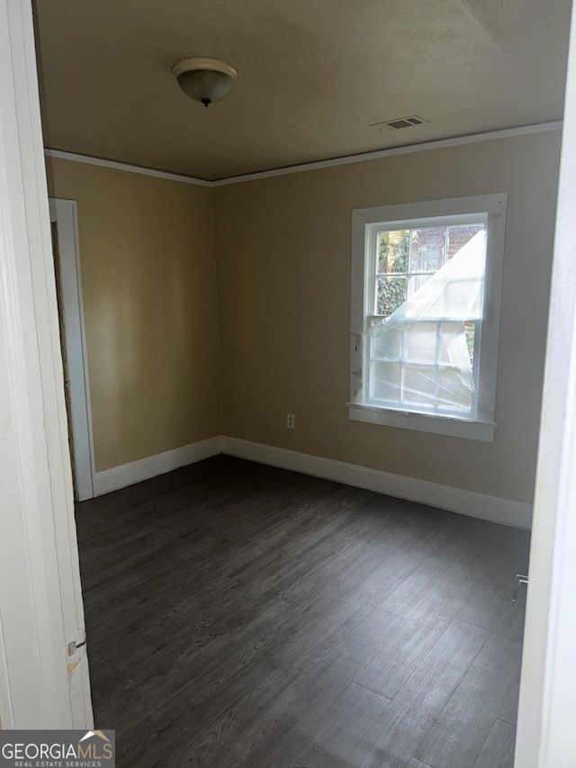 spare room with crown molding and dark hardwood / wood-style floors