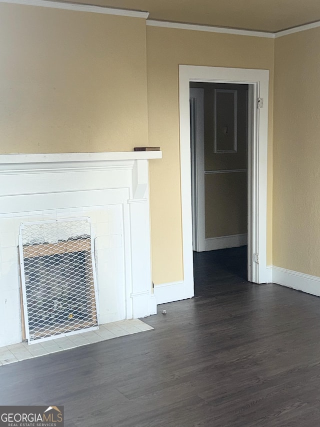 unfurnished living room featuring crown molding, dark hardwood / wood-style flooring, and a tiled fireplace