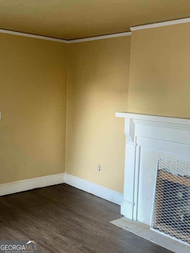 unfurnished living room featuring crown molding, wood-type flooring, and a tiled fireplace