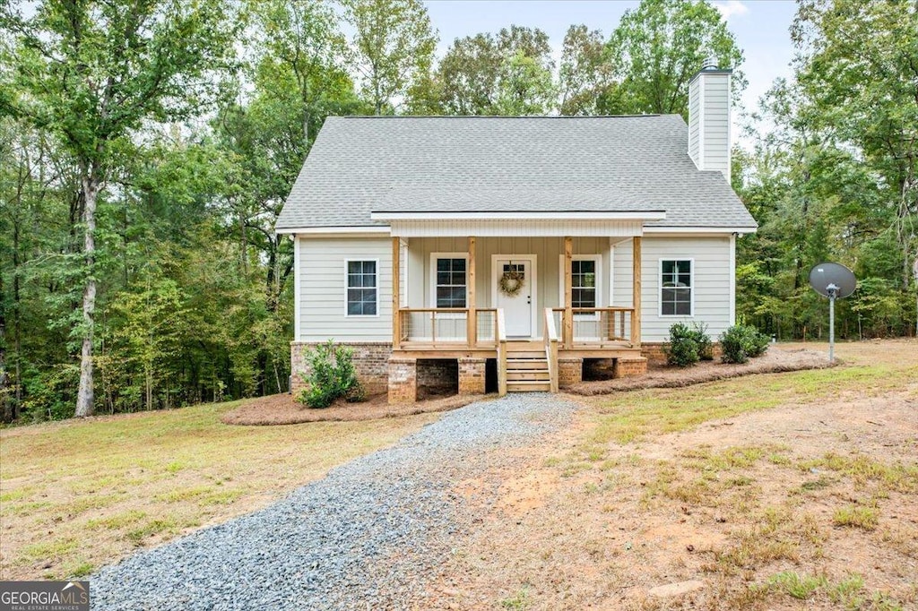 new england style home with a porch and a front lawn