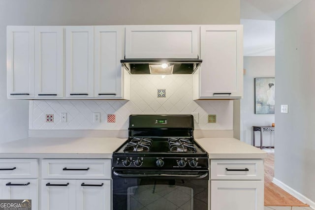 kitchen featuring backsplash, black gas stove, and white cabinets