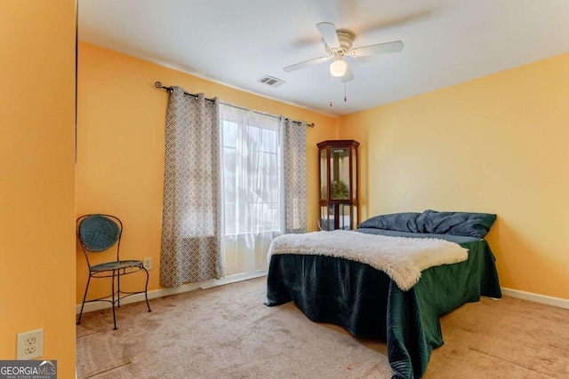 bedroom with a ceiling fan, light colored carpet, visible vents, and baseboards