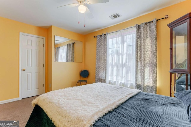 carpeted bedroom with ceiling fan, visible vents, and baseboards