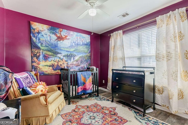 sitting room featuring baseboards, ceiling fan, visible vents, and wood finished floors