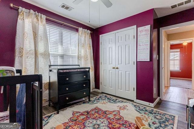 bedroom featuring baseboards, a closet, visible vents, and wood finished floors