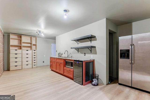 kitchen featuring stainless steel appliances, sink, and light hardwood / wood-style flooring