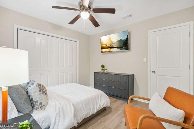 bedroom featuring ceiling fan, light hardwood / wood-style floors, and a closet