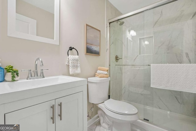 bathroom with walk in shower, vanity, and toilet