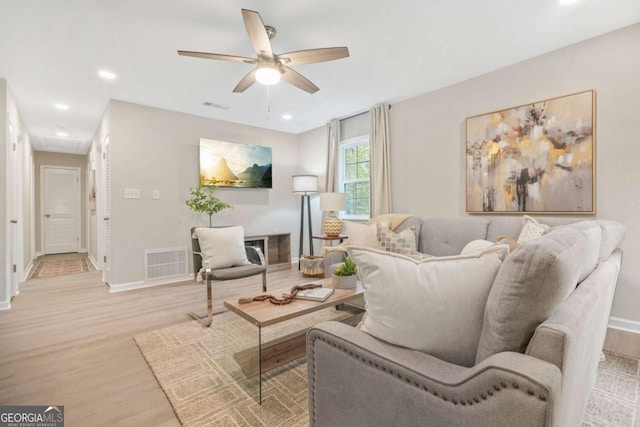 living room featuring ceiling fan and light hardwood / wood-style floors