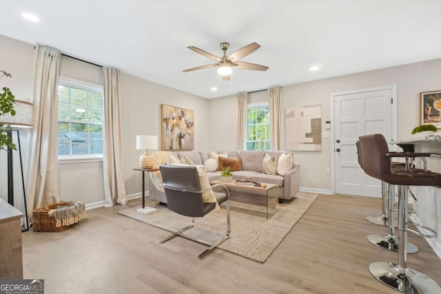 living room with ceiling fan and light hardwood / wood-style flooring