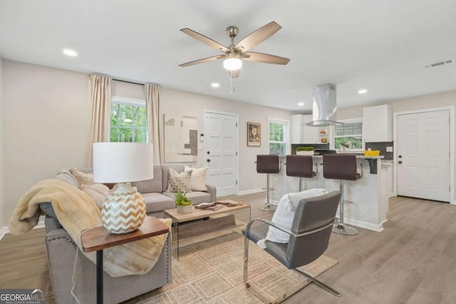 living room featuring ceiling fan and light hardwood / wood-style floors